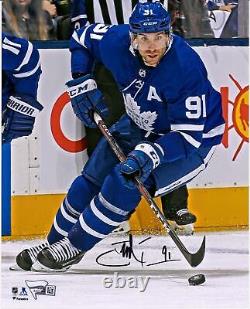 John Tavares Toronto Maple Leafs Signed 8 x 10 Blue Jersey Skating & Puck Photo