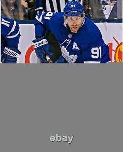 John Tavares Toronto Maple Leafs Signed 8 x 10 Blue Jersey Skating & Puck Photo